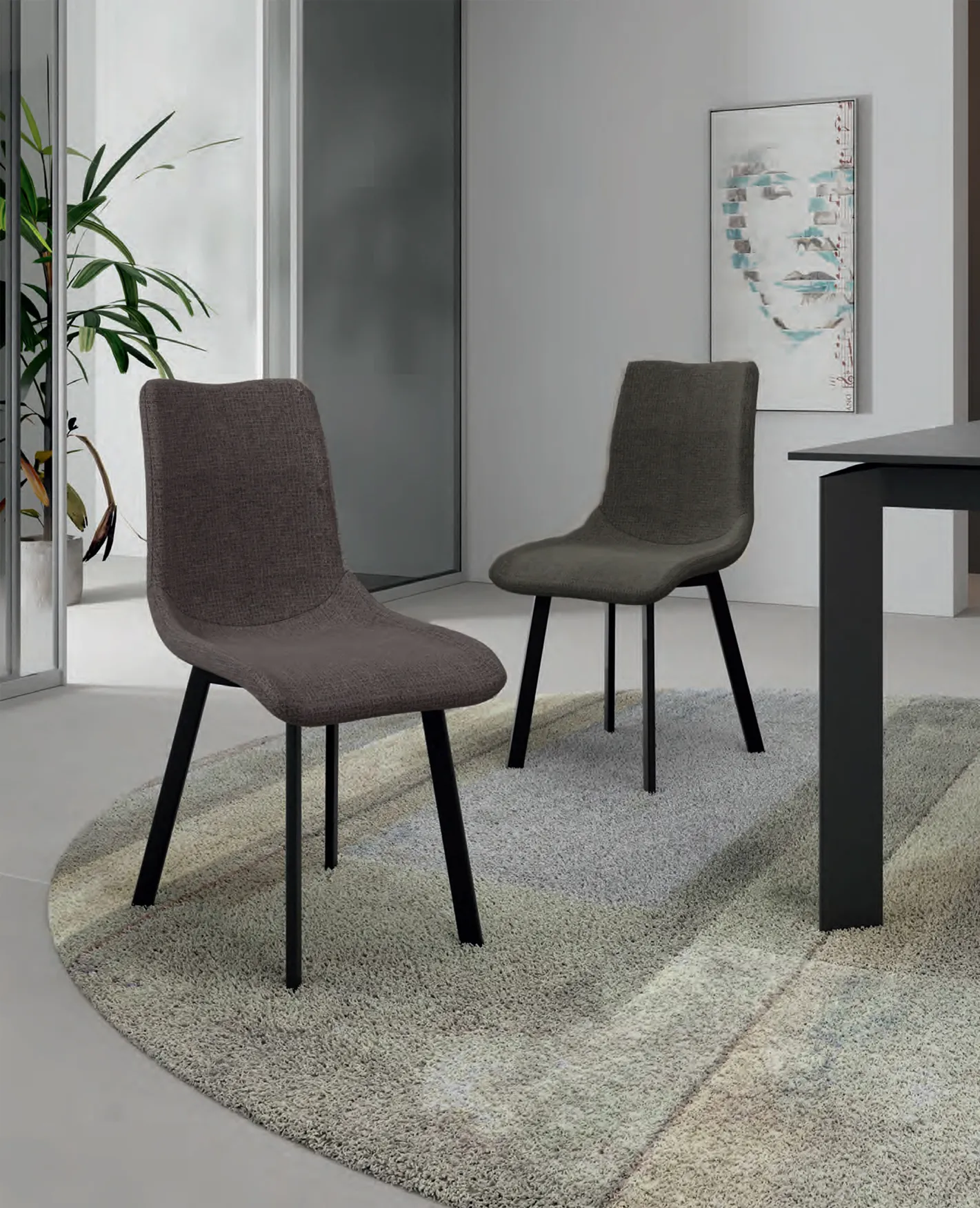 Sedie Iris Stones grigio scuro su un tappeto rotondo accanto a un tavolo