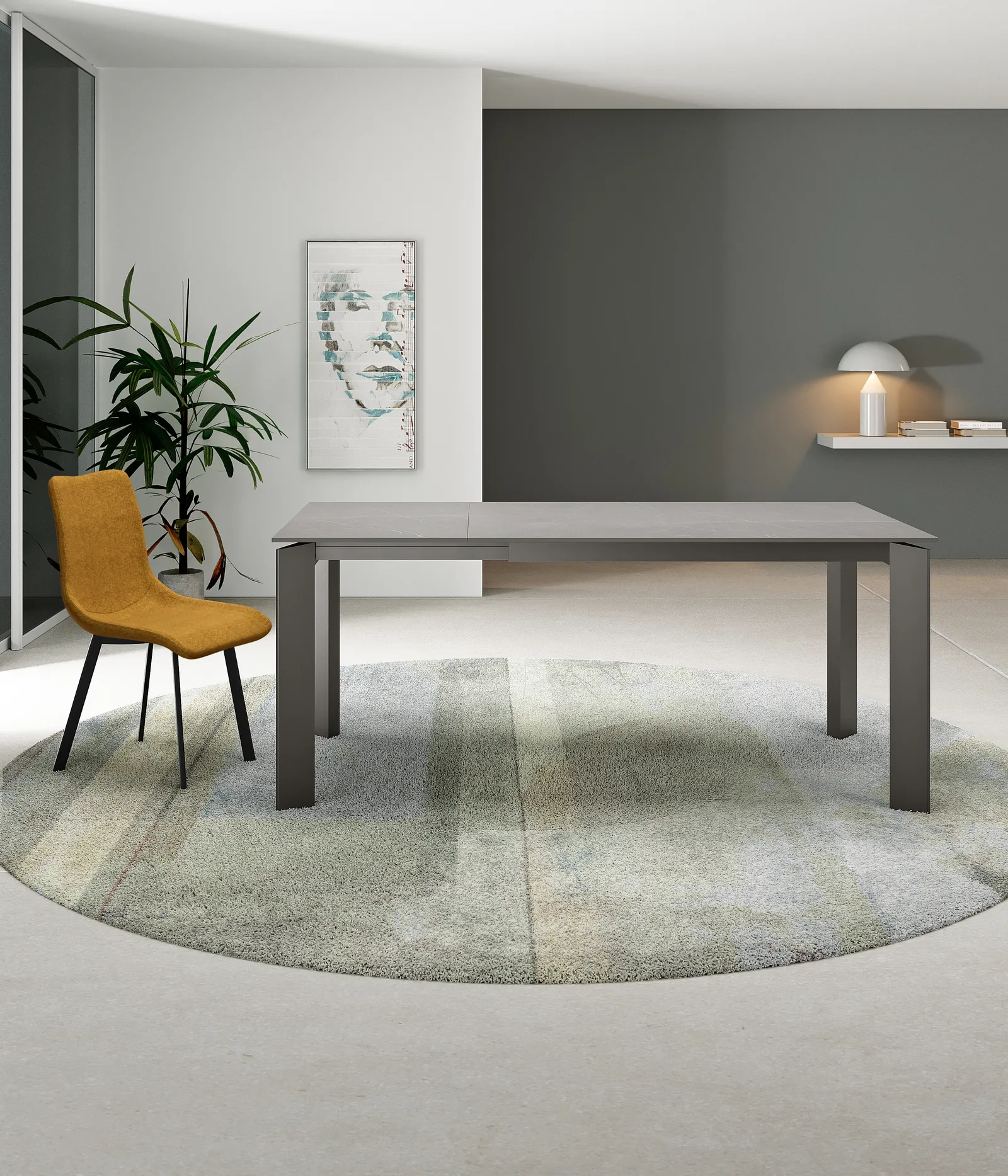 Tavolo Frame Stones in marmo grigio con struttura antracite su un tappeto rotondo