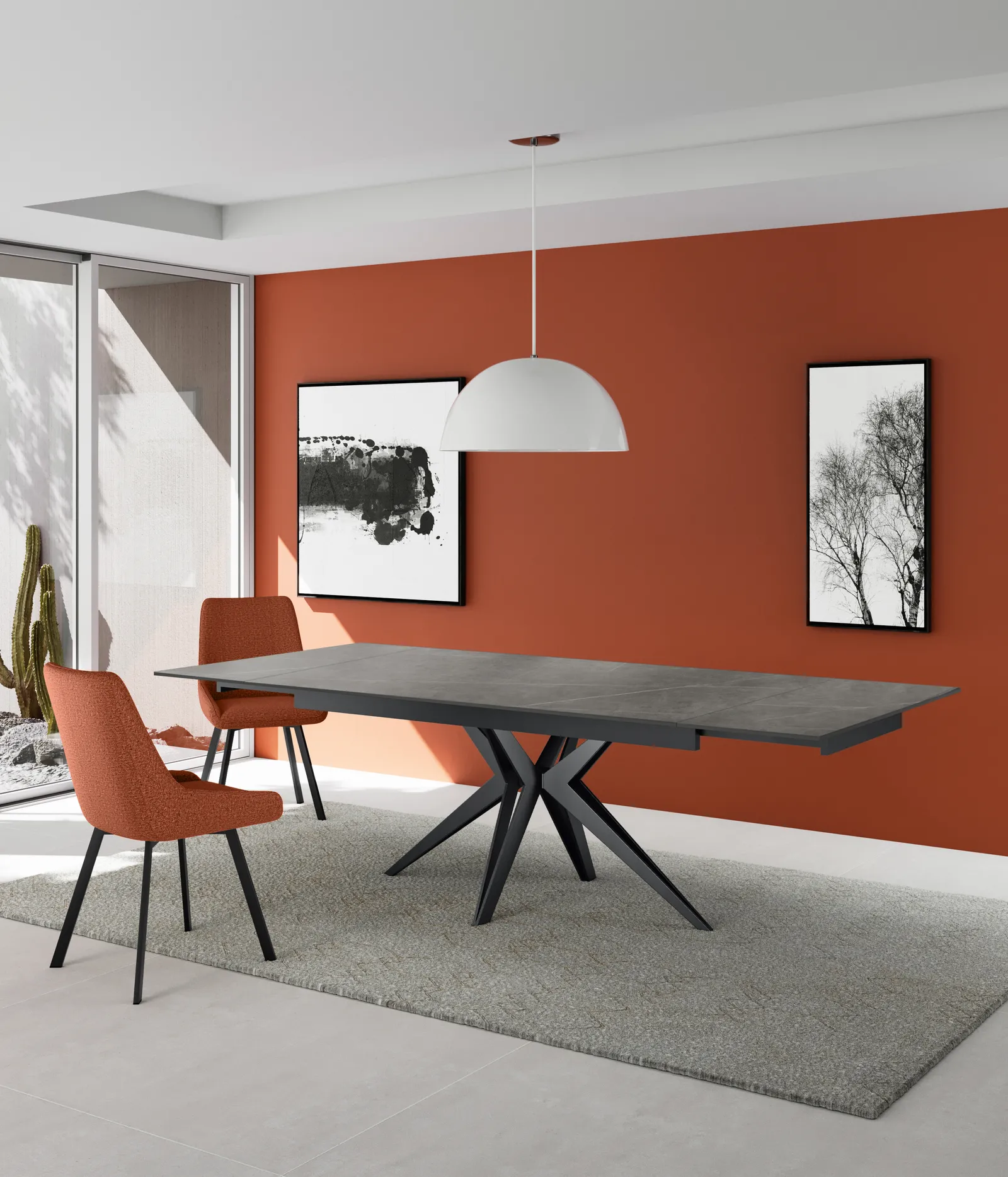 Tavolo Match 2 Stones marmo grigio con sedie arancio davanti a una parete rossa