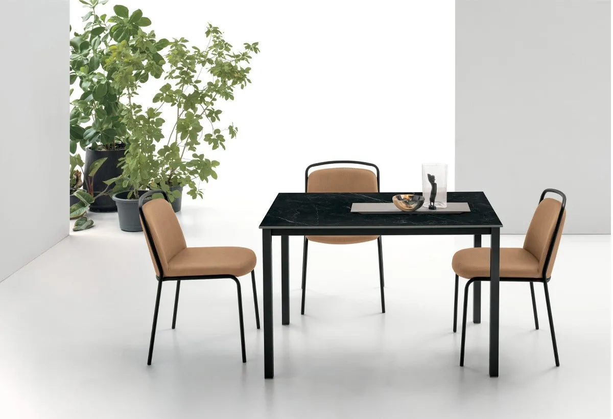 Tavolo Pellicano Target Point con piano nero effetto marmo e sedie color cuoio su fondo bianco