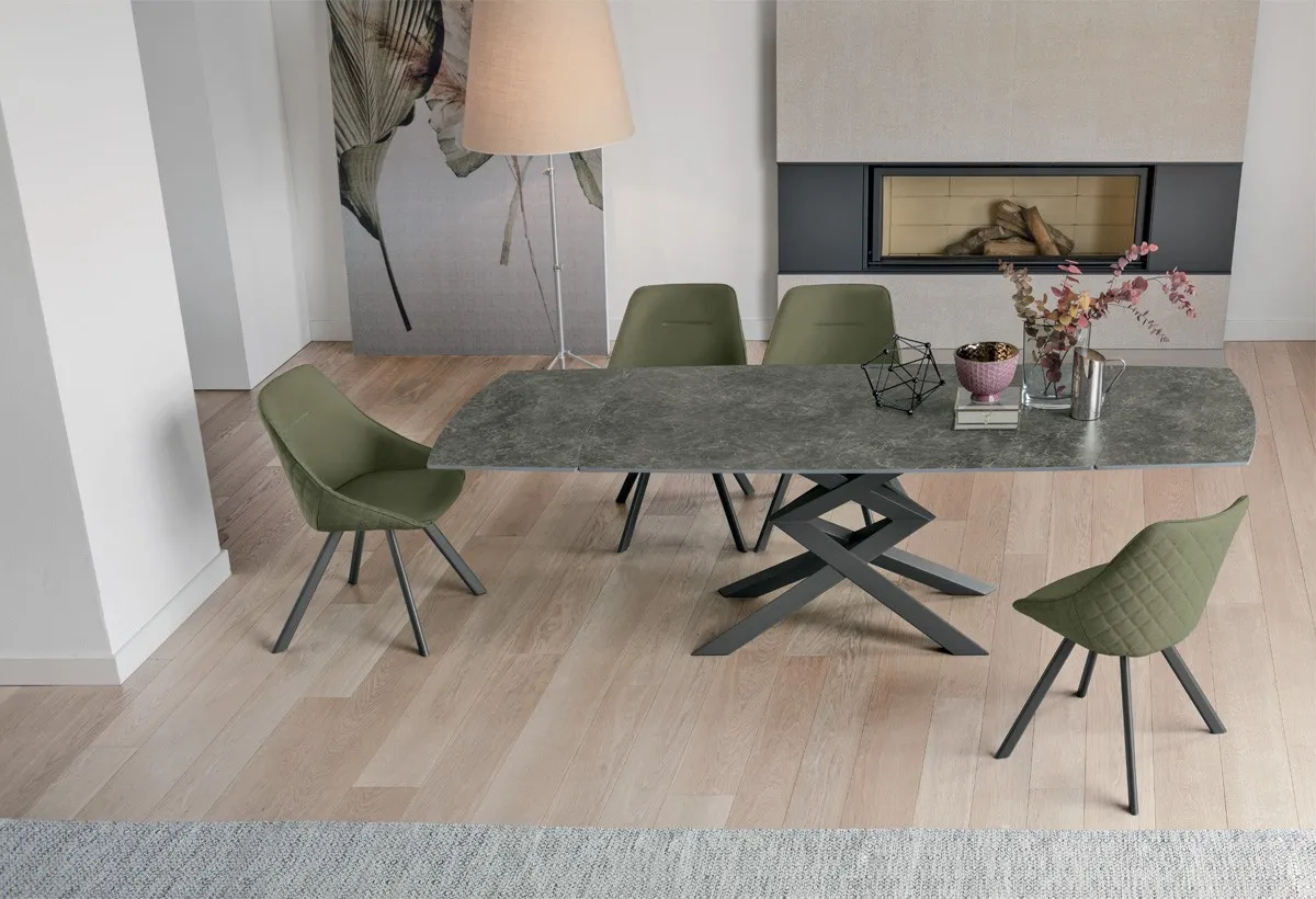 Tavolo Cross Target Point con piano grigio e gambe incrociate nere, sedie verdi su parquet