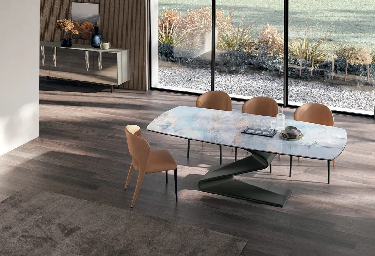 Tavolo Zed Target Point con base a Z nera e piano effetto marmo, sedie arancio davanti alla vetrata