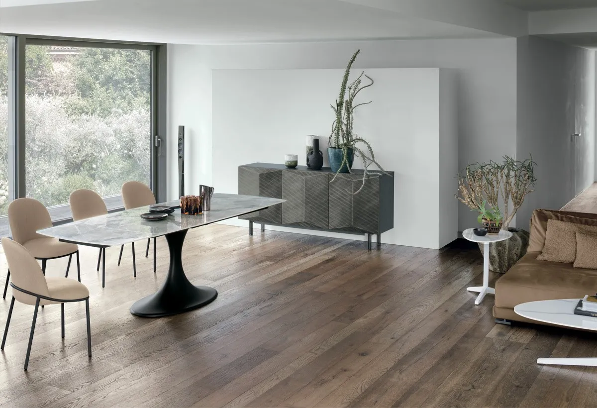 Tavolo Calice Target Point con base nera e piano chiaro, sedie beige in un soggiorno con parquet