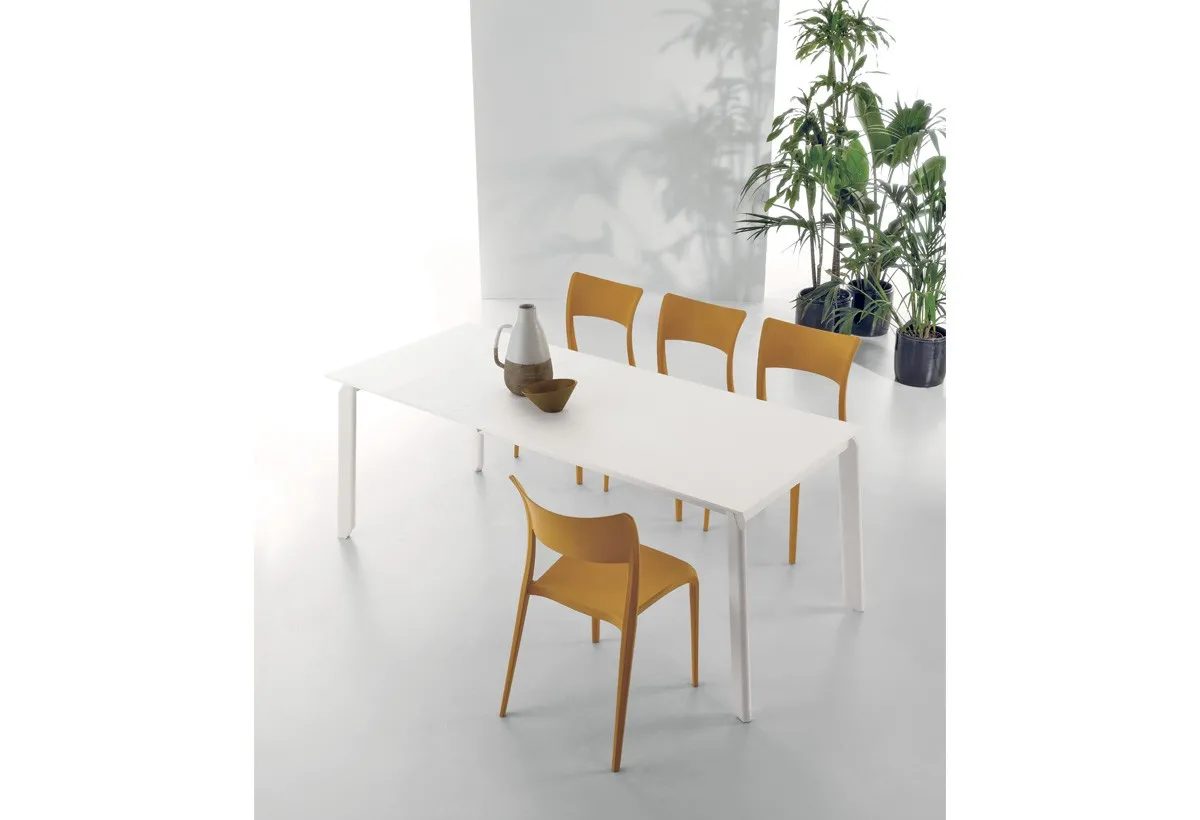 Tavolo Efesto Target Point bianco con sedie color senape su fondo chiaro