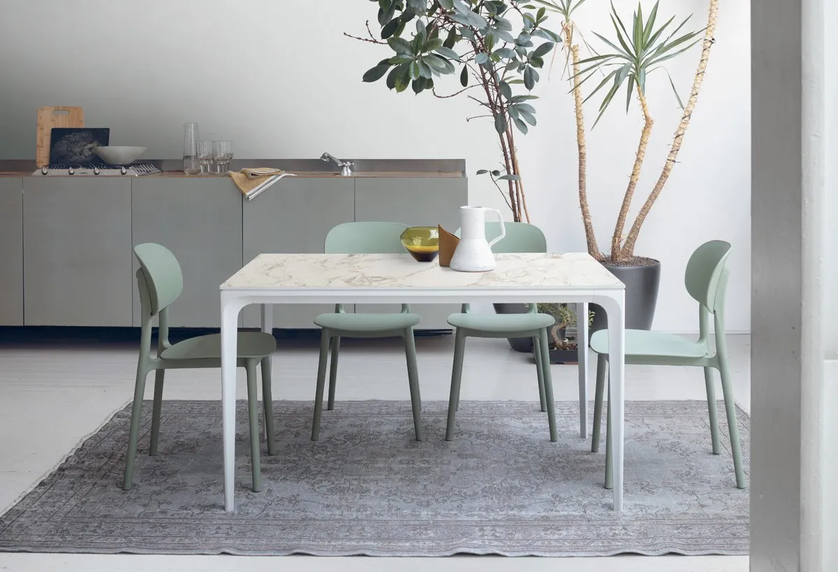 Tavolo Mercury Target Point bianco con piano effetto marmo e sedie verde salvia in cucina