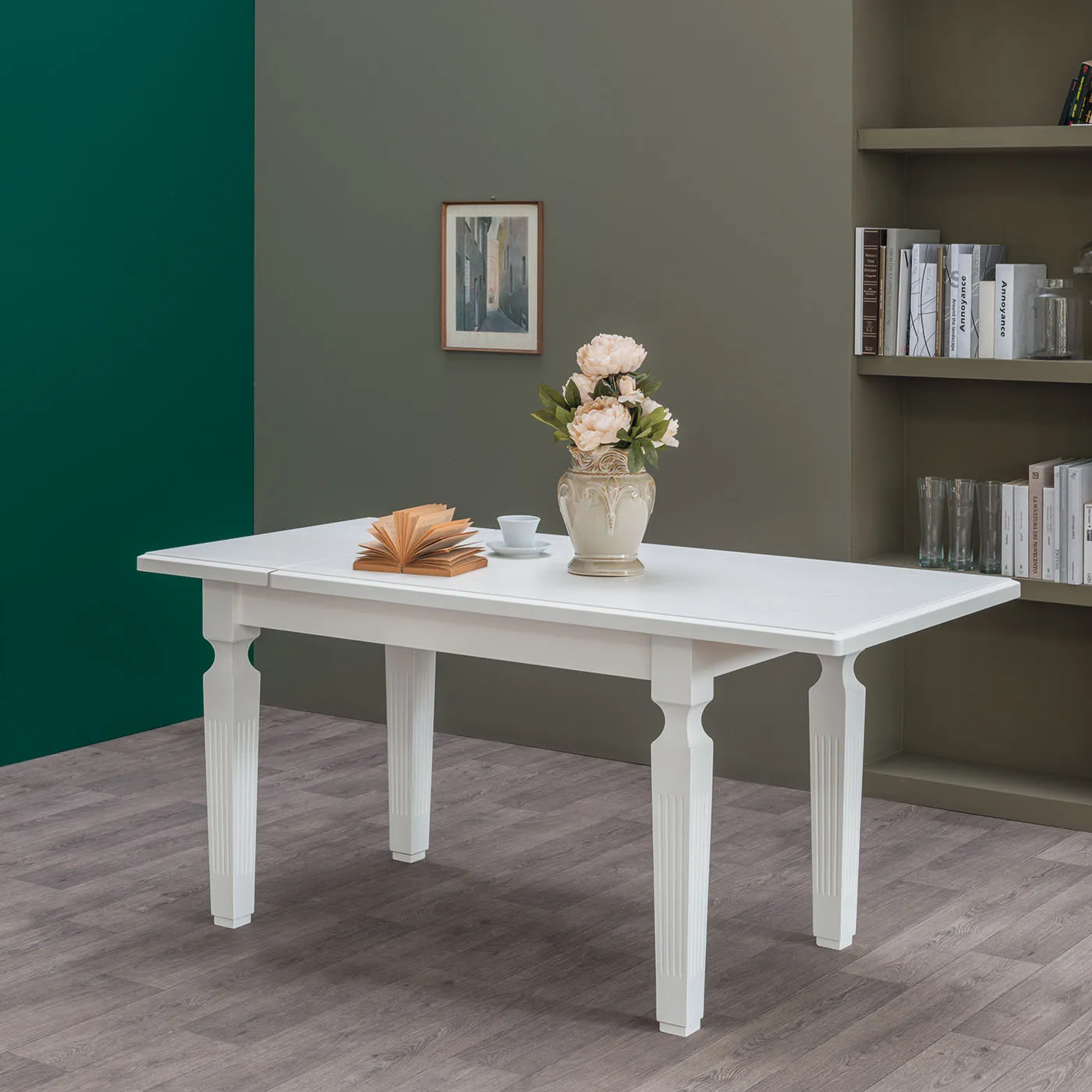 Tavolo Impero Tecnolegno laccato bianco con gambe tornite in un ambiente verde