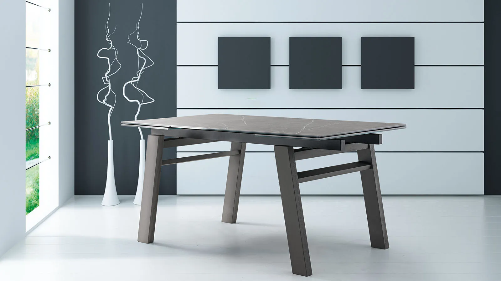 Tavolo allungabile Chicago Tecnolegno con piano scuro e gambe in legno inclinate in un ambiente bianco