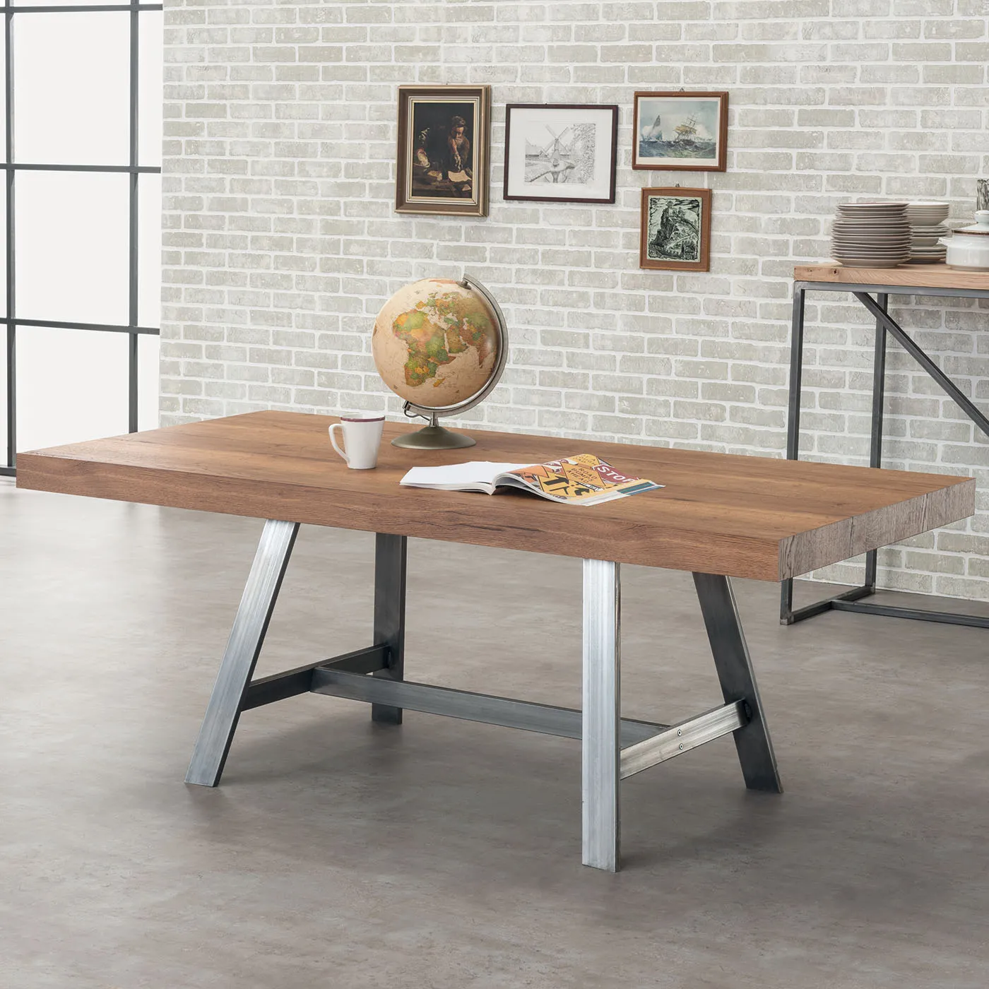 Tavolo Madrid Tecnolegno con piano in legno e basamento in ferro con un mappamondo sul piano