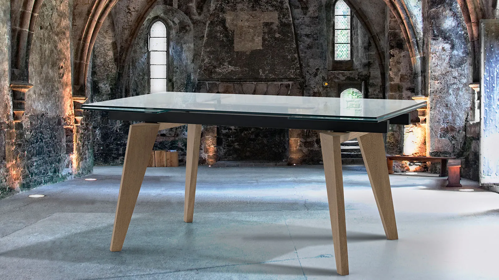 Tavolo Nizza Tecnolegno con piano in vetro e gambe in rovere in un ambiente con archi in pietra
