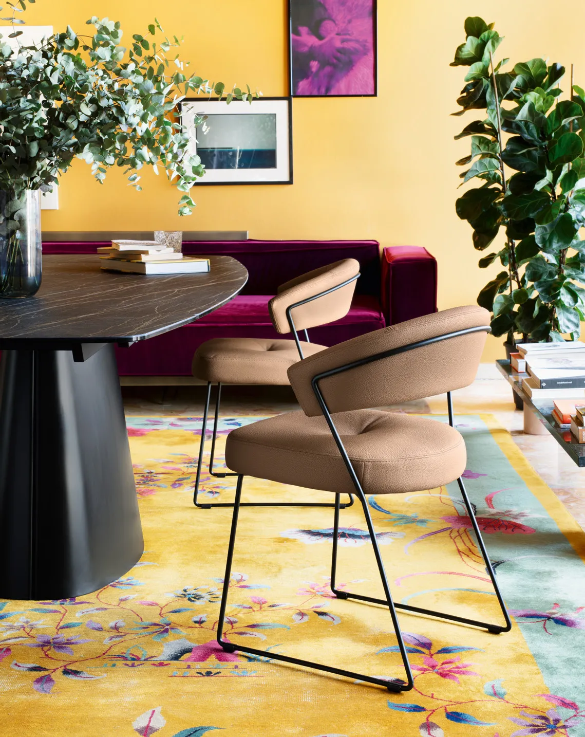 Sedia NY Anniversary Connubia in similpelle tabacco con struttura nera su un tappeto giallo a fiori