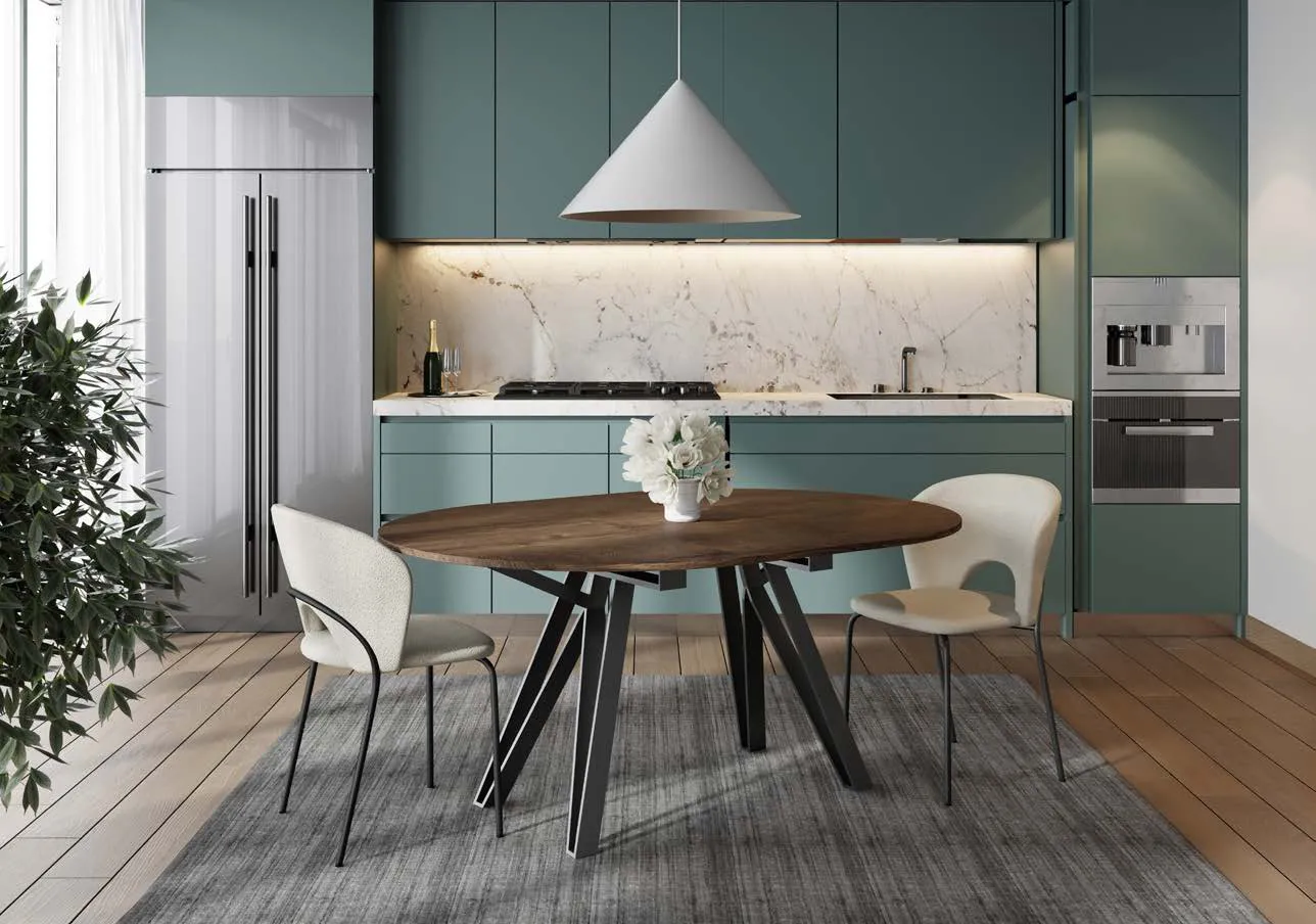 Tavolo Apple Zamagna rotondo in una cucina verde con sedie chiare