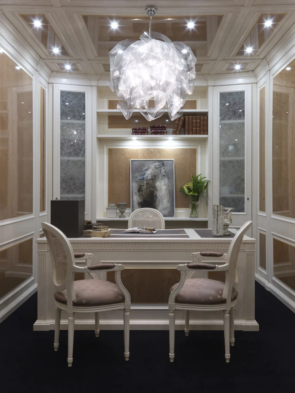 Studio Wagner Bernazzoli con scrivania, poltroncine ovali e vetrine illuminate