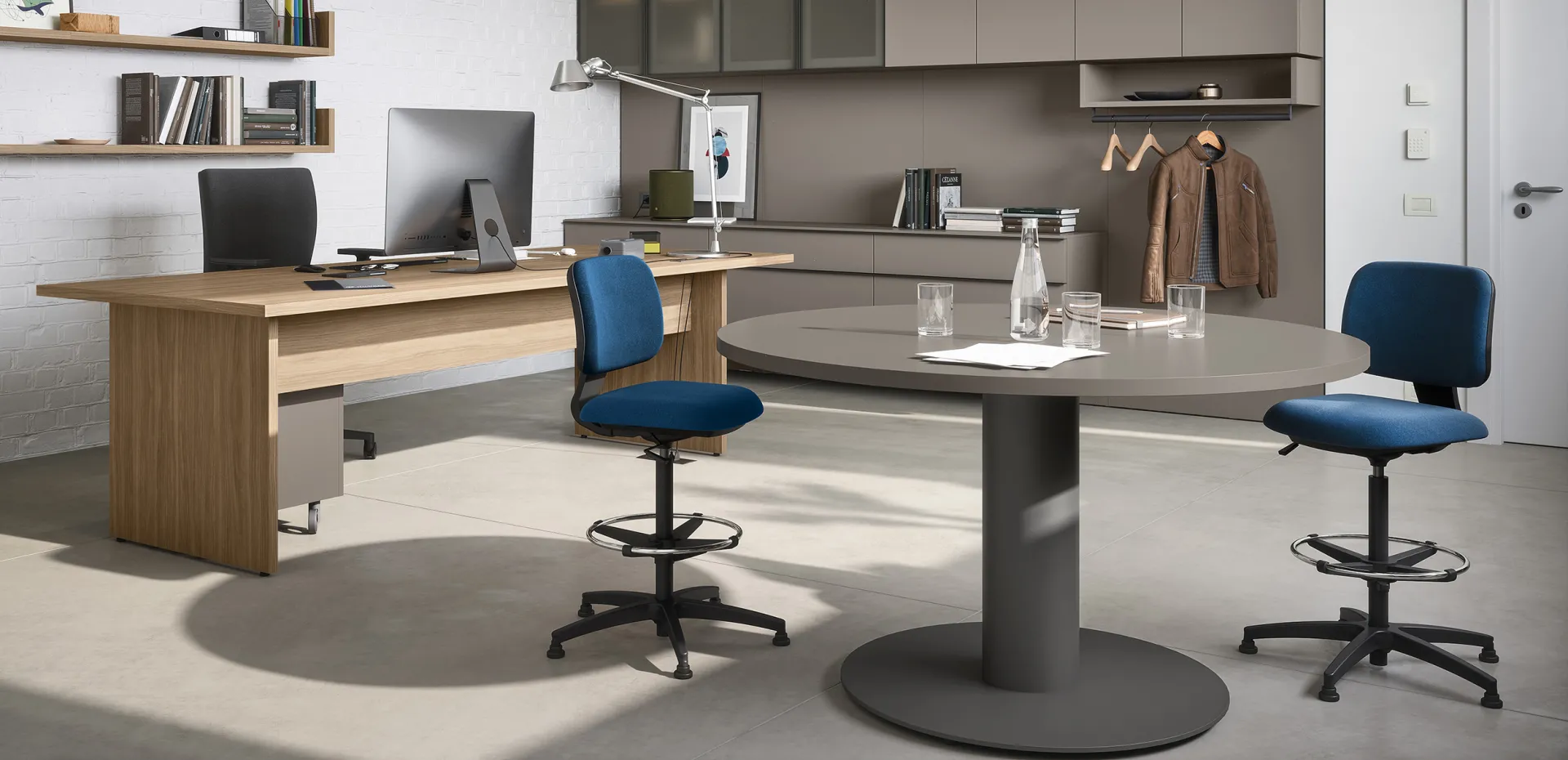Tavolo riunioni circolare dinamico Cinquanta3 con sgabelli blu in ufficio