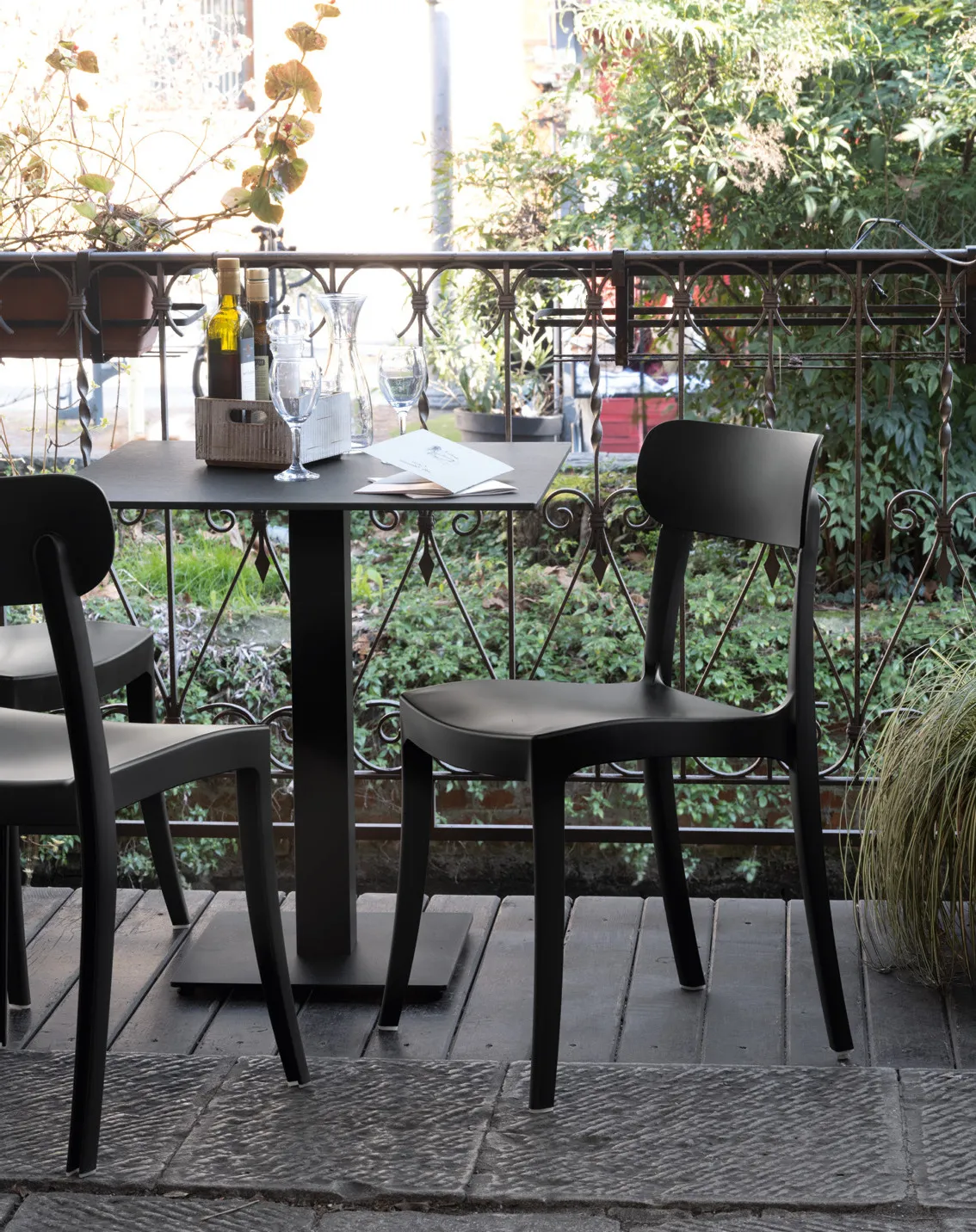 Sedie Locanda Connubia nere attorno a un tavolino da bistrot su un balcone con ringhiera