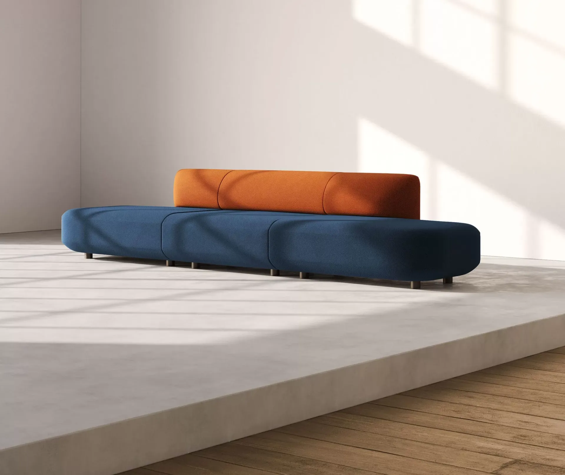 Divano Afina Frezza con moduli blu e schienale arancio in una sala luminosa