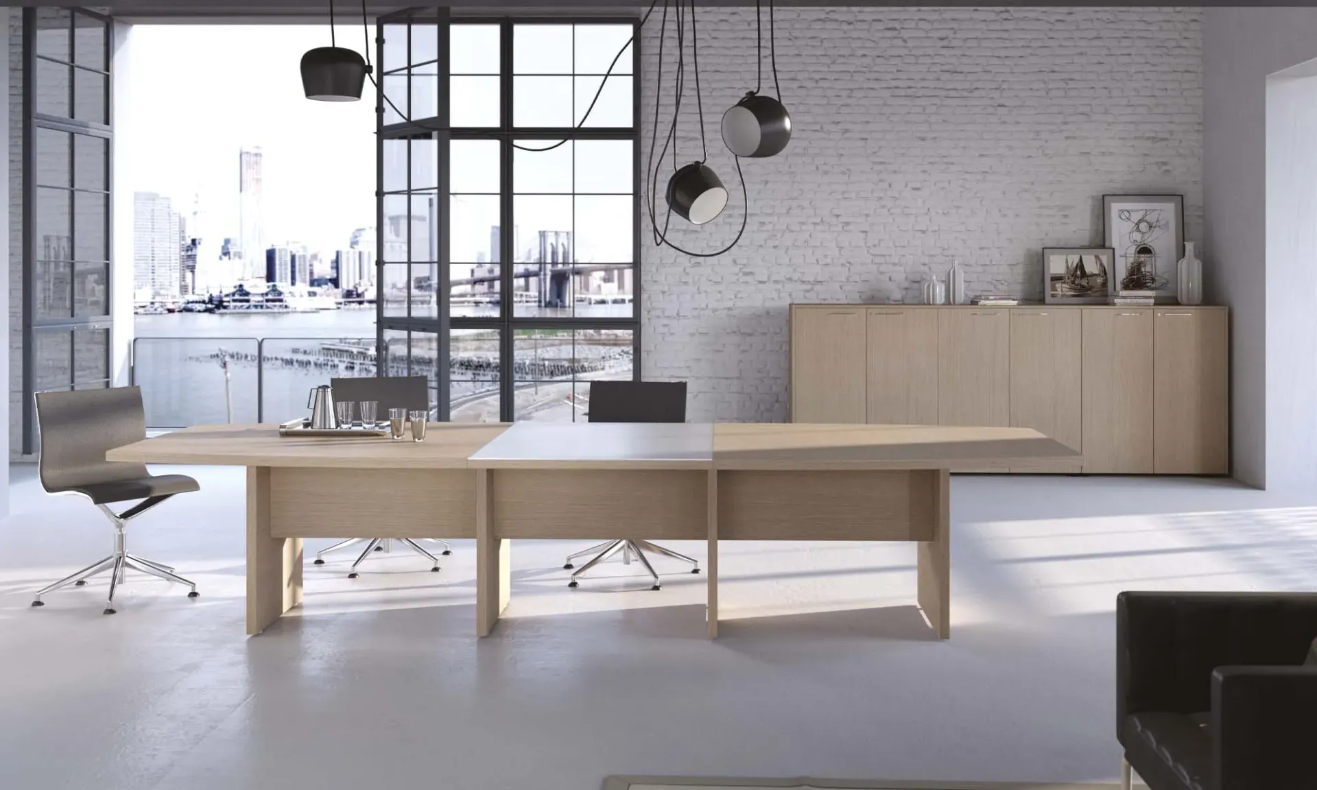 Tavolo riunione Asset Frezza in legno chiaro su pannelli in una sala con vetrate