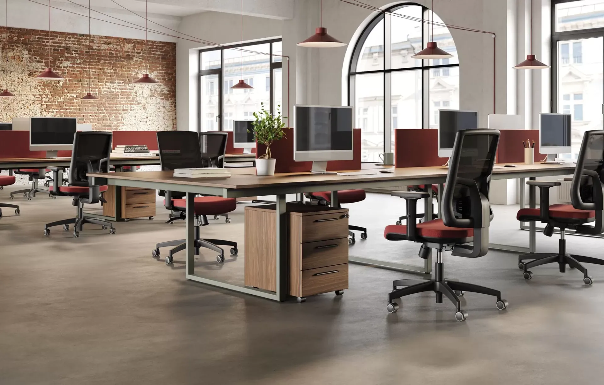 Bench Be.1 Frezza con schermi rossi e sedie nere in un open space con mattoni a vista