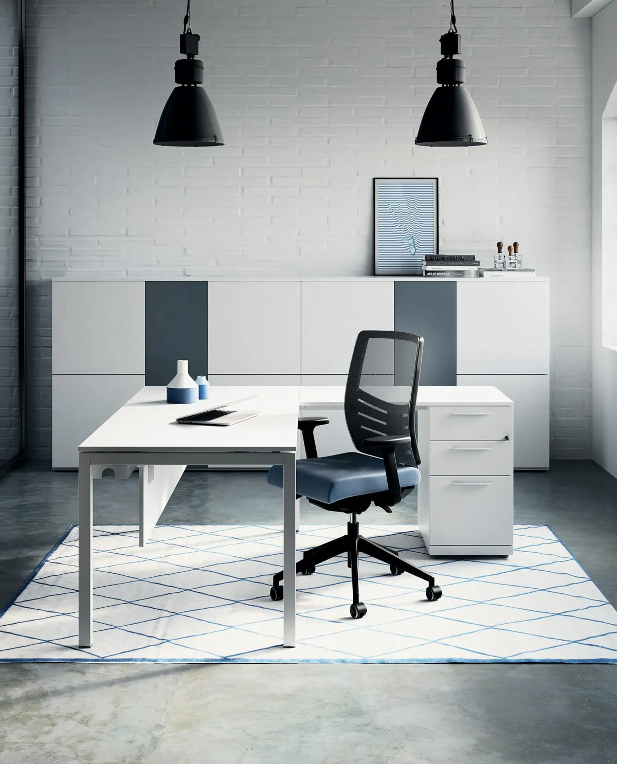 Scrivania Pop Easy Frezza con cassettiera e sedia nera sotto lampade industriali