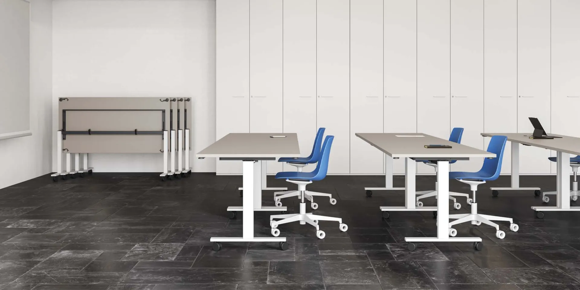 Tavoli Pop Folding Frezza separati con sedie blu e altri tavoli ripiegati sul fondo