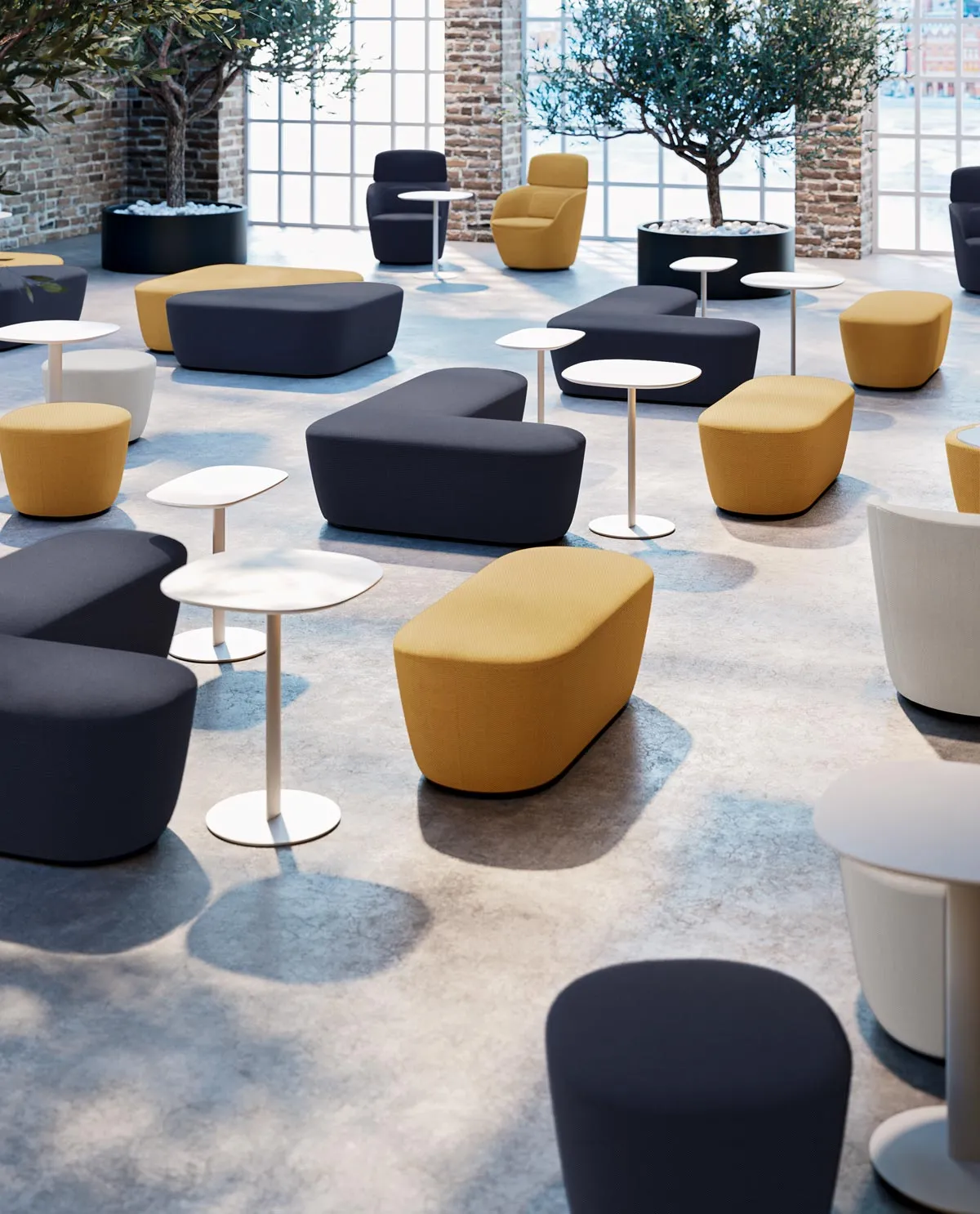 Tavolini lounge Radar Frezza bianchi fra pouf colorati in una sala luminosa