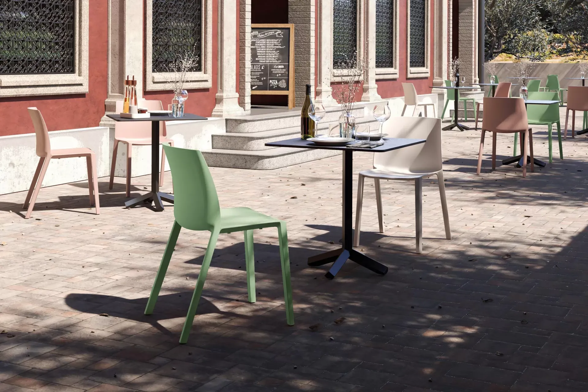 Sedie Ador Frezza verde e bianca in un cortile con portici rossi