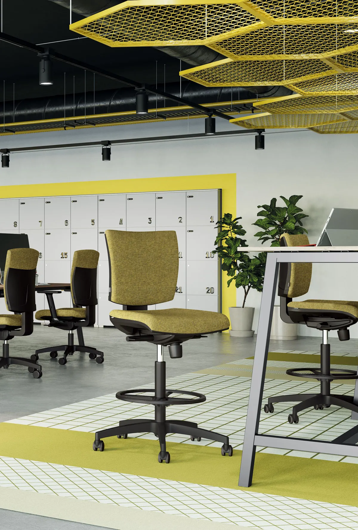 Sgabello ergonomico EM 59 Frezza giallo con poggiapiedi accanto a scrivanie