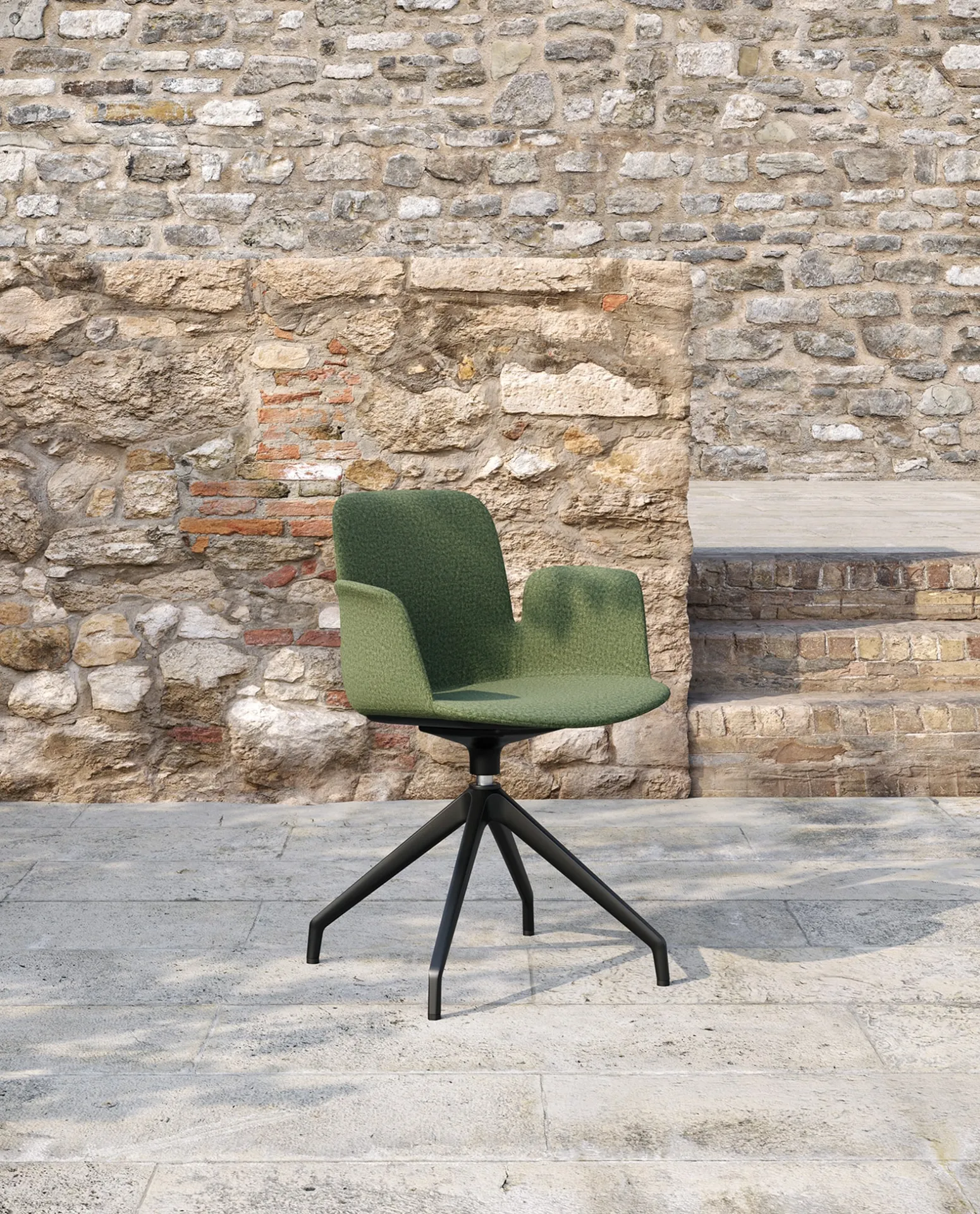 Poltroncina Fior di Loto Upholstered Frezza verde su base girevole davanti a un muro in pietra