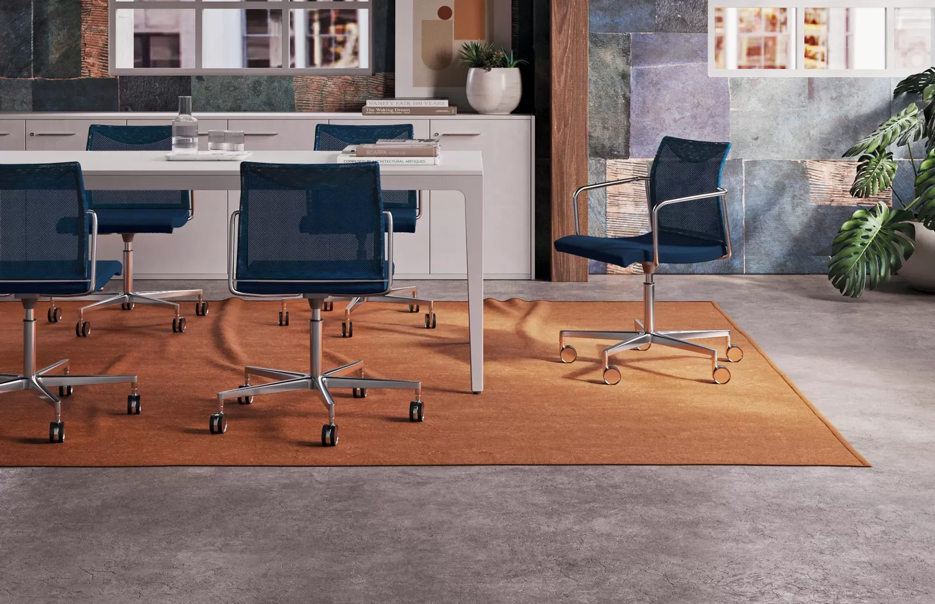 Sedie Frame Frezza blu su ruote attorno a un tavolo su tappeto arancio