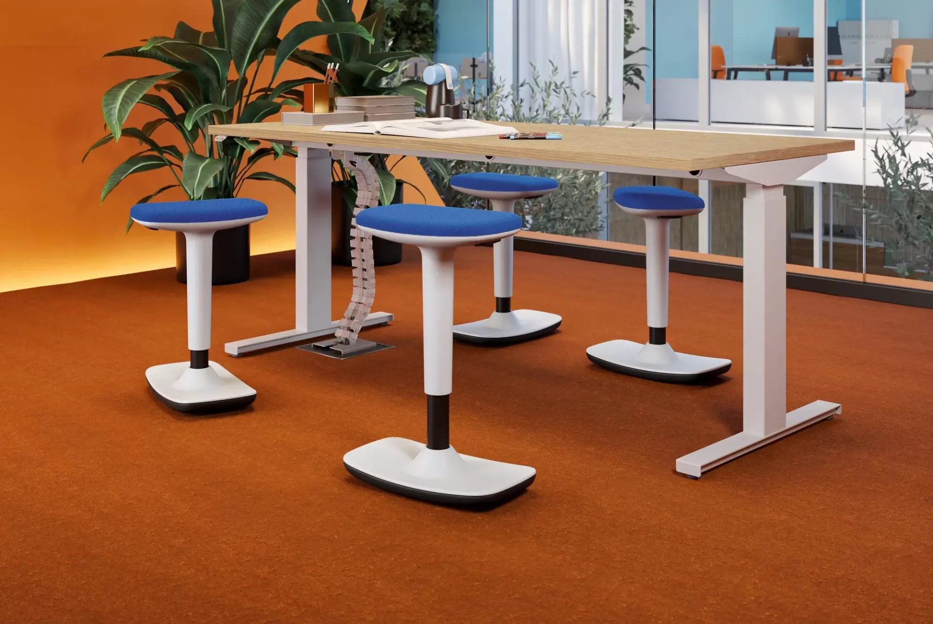 Sgabelli Like Frezza blu attorno a una scrivania alta su moquette arancio