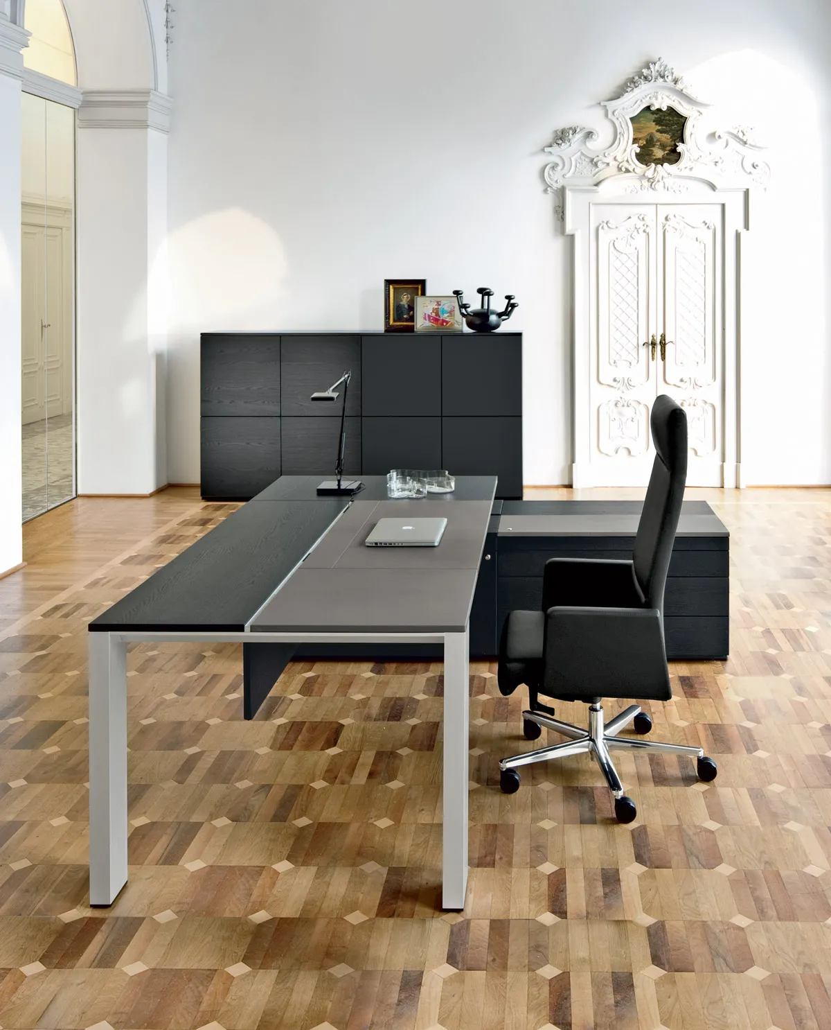 Sedia direzionale Max Frezza nera in un ufficio con parquet e mobile scuro