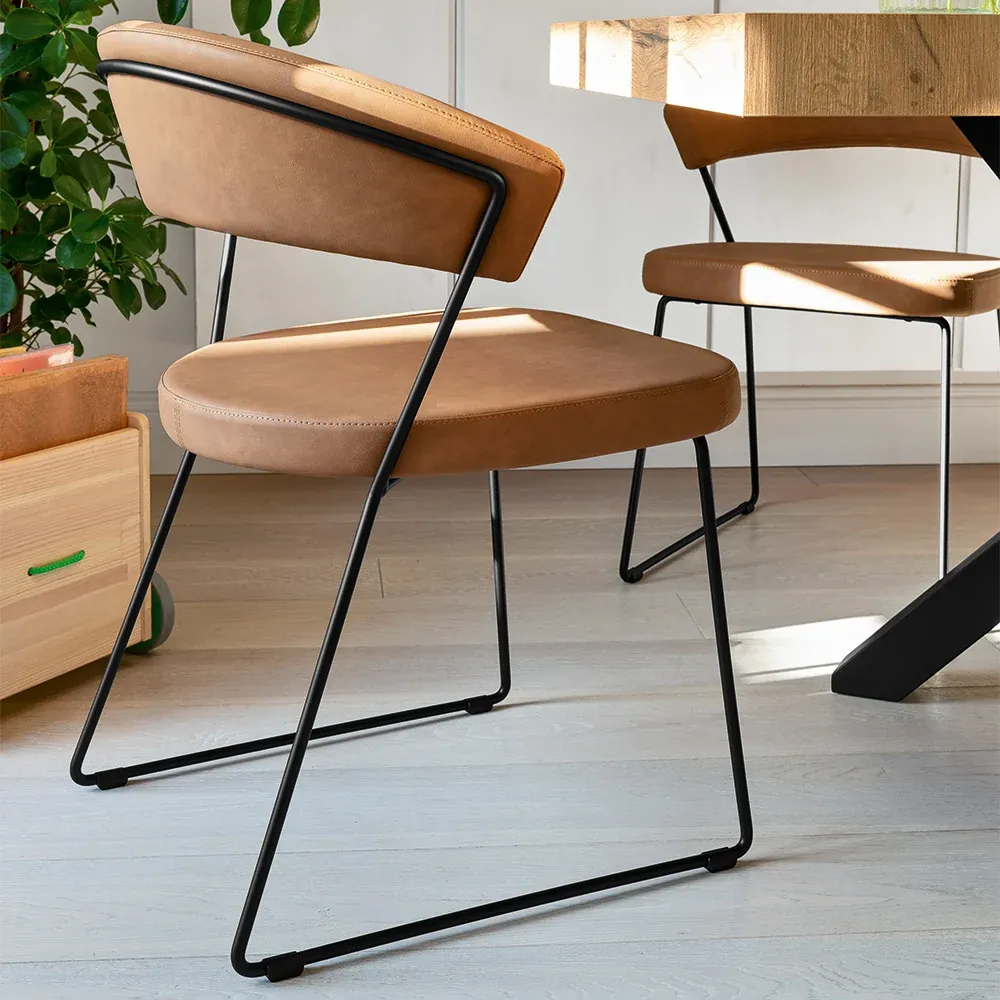 Sedia New York Connubia in pelle color cuoio con base a slitta nera vista di tre quarti