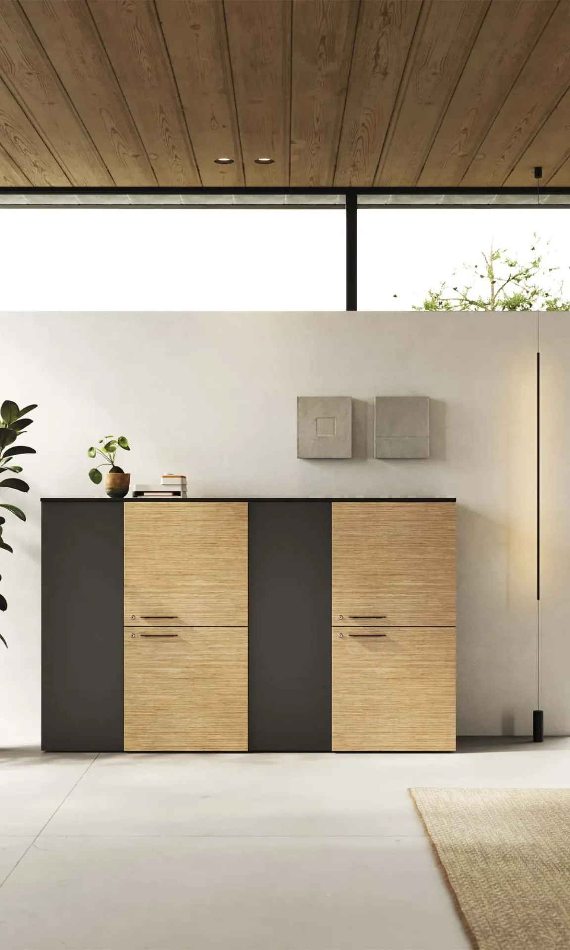 Armadio Madia Frezza alto con ante nere e in legno sotto un soffitto in listelli