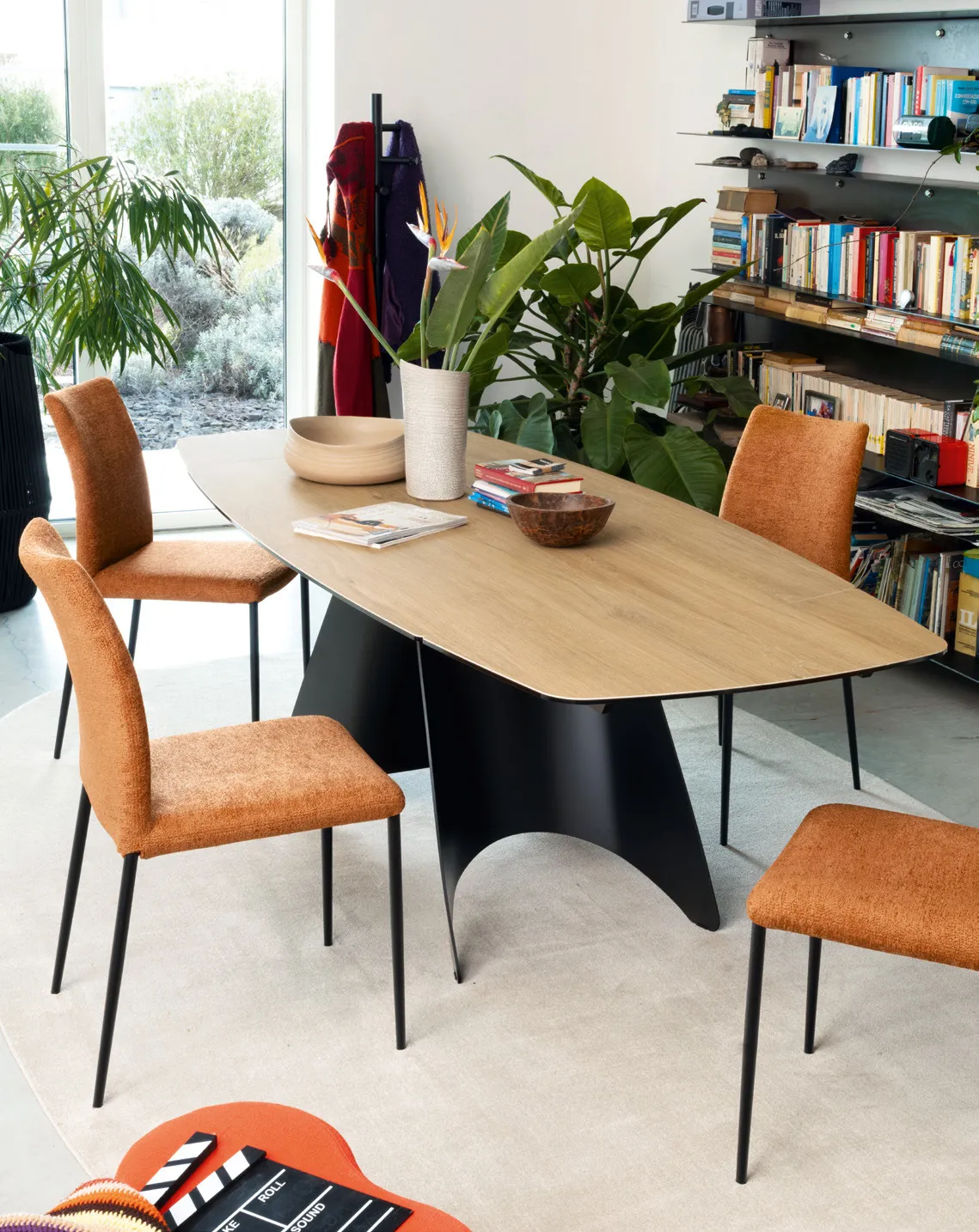 Tavolo Orion Connubia sagomato con piano in ceramica effetto rovere e base nera, con sedie arancio