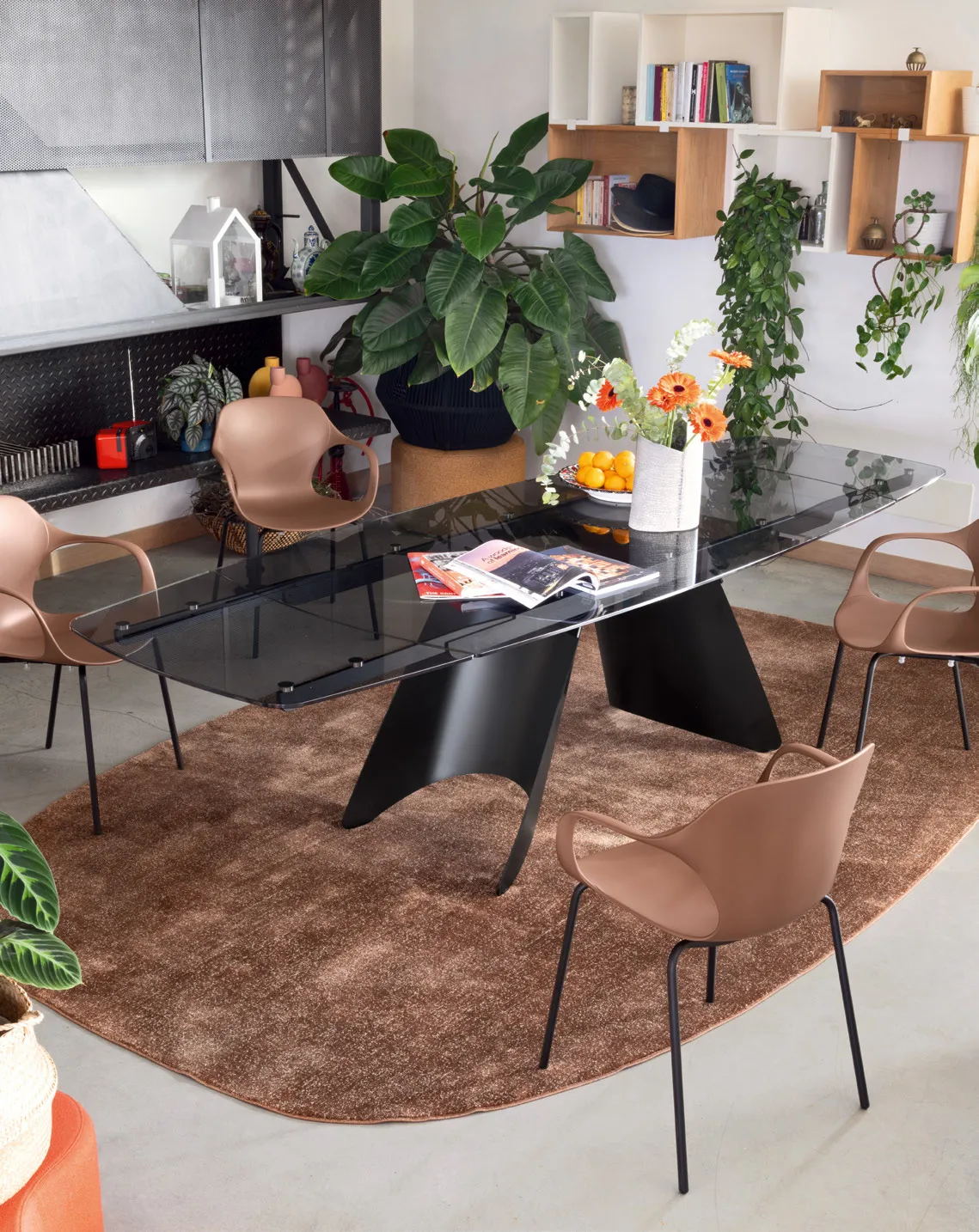Tavolo Orion Connubia con piano in vetro grigio fumé e base nera, con sedie in plastica terracotta