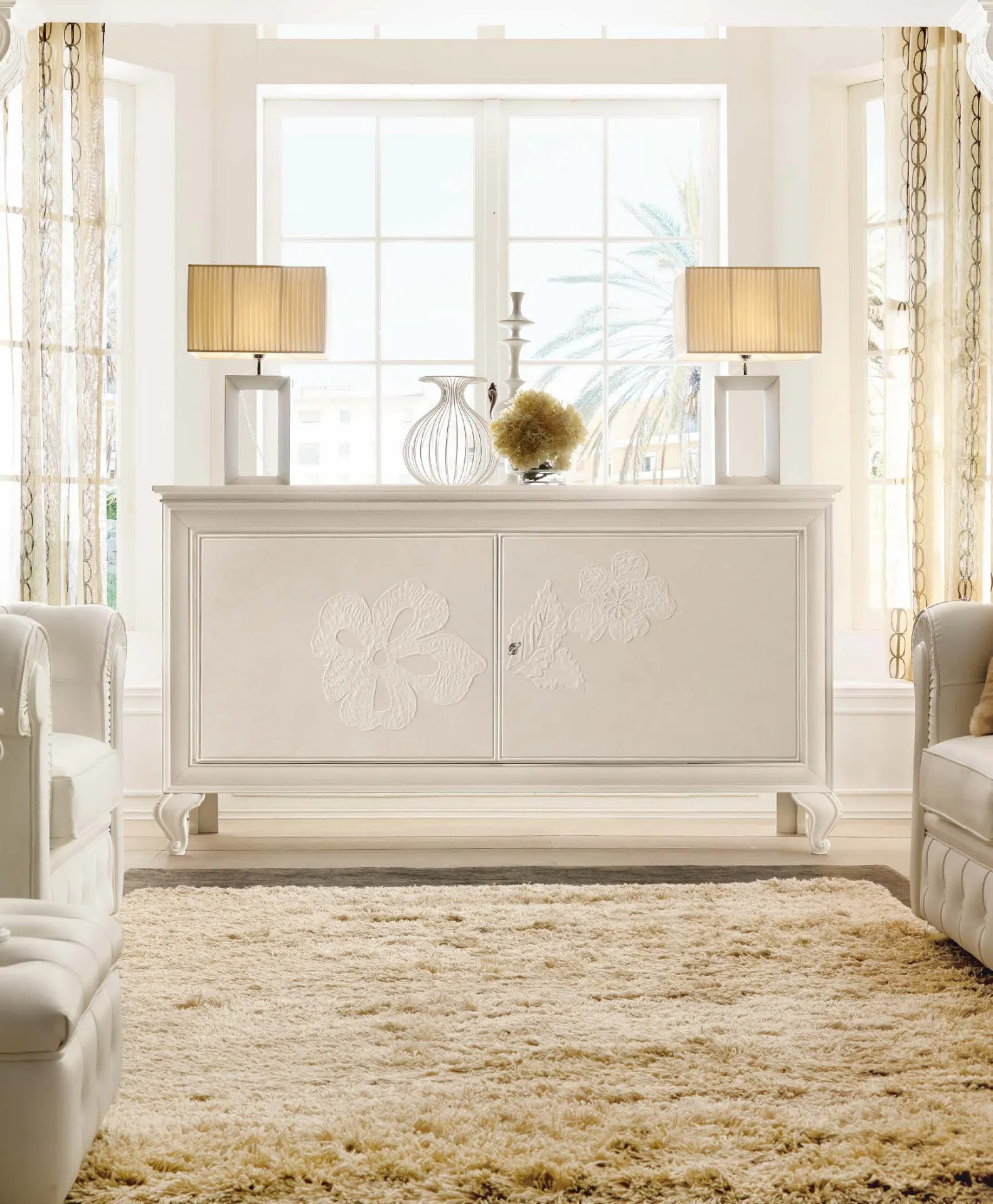 Credenza Albert Avenanti bianca con decoro floreale tra due lampade da tavolo