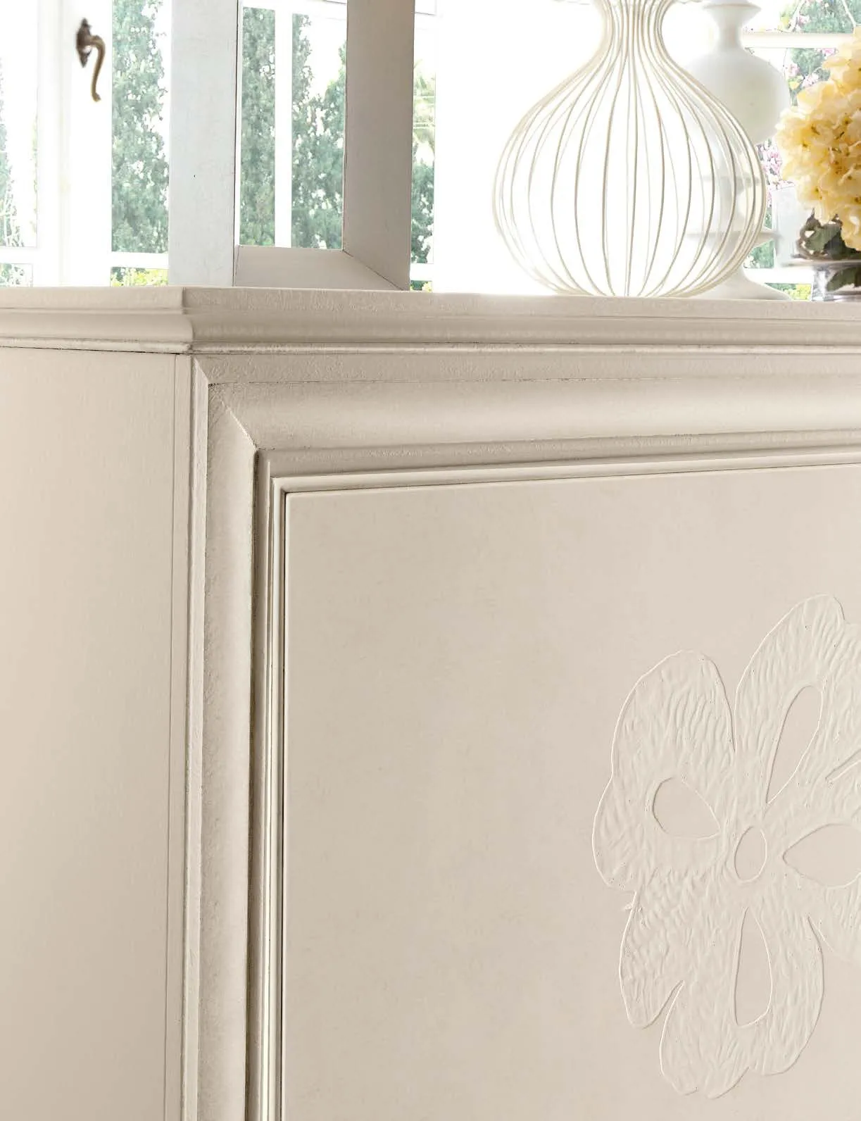 Particolare del decoro floreale in rilievo sull'anta della credenza Albert Avenanti