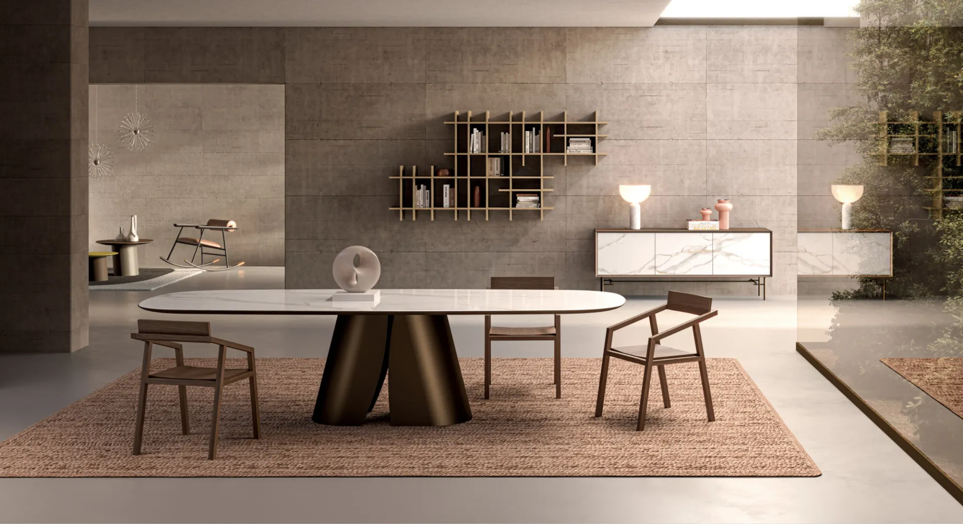 Tavolo Cosmopolitan Ceramics Devina Nais con piano effetto marmo e basamento bronzo in una sala con parete in pietra
