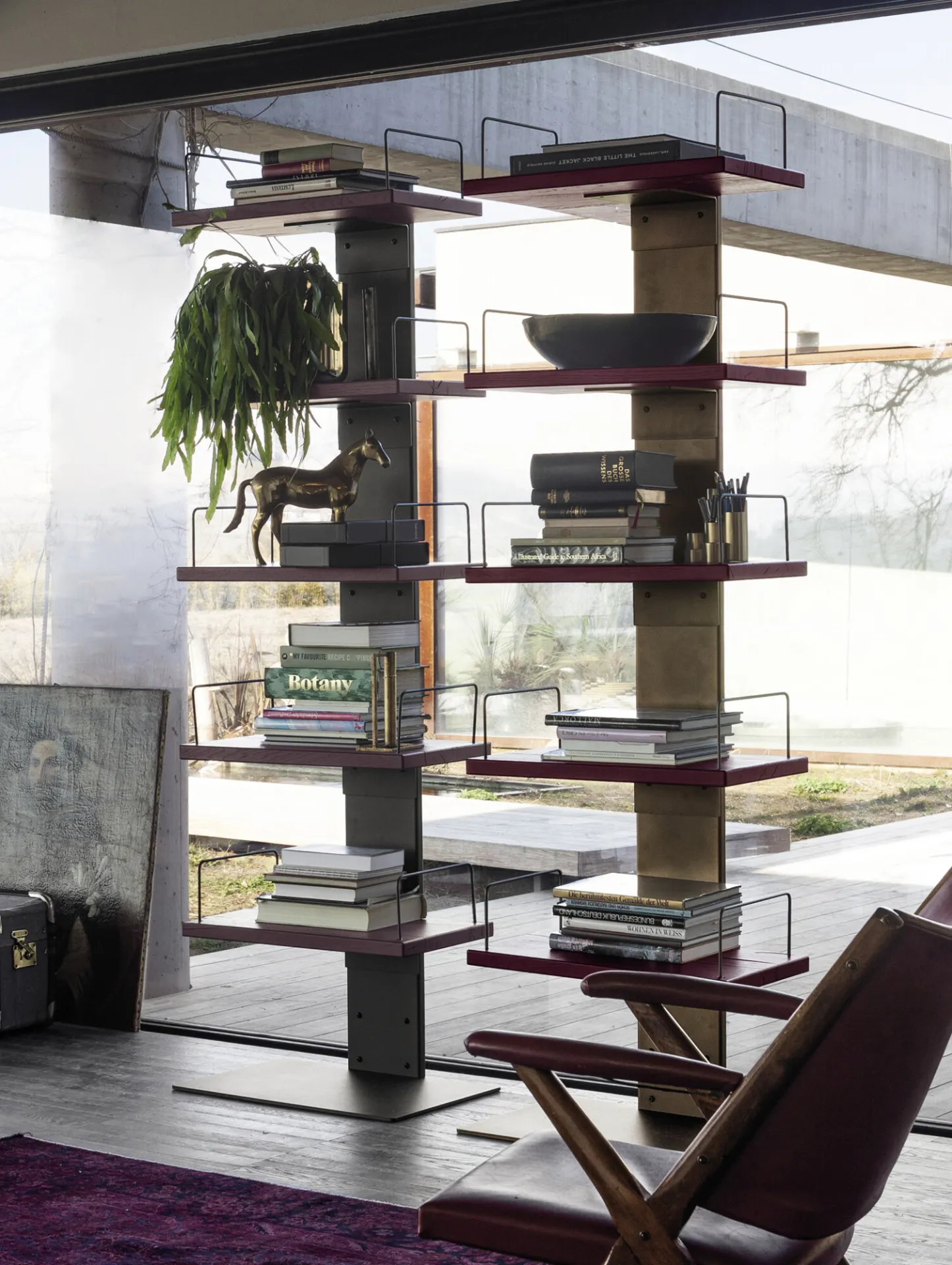 Libreria Infinity Devina Nais con libri e piante davanti a una vetrata