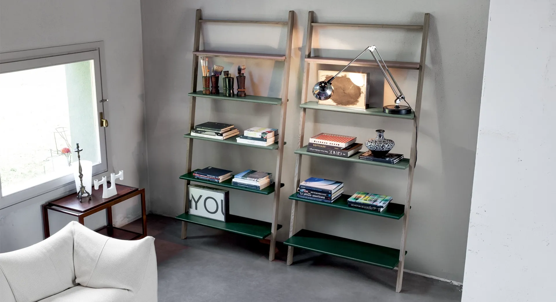 Due librerie Klass Devina Nais in rovere con ripiani verdi in un soggiorno