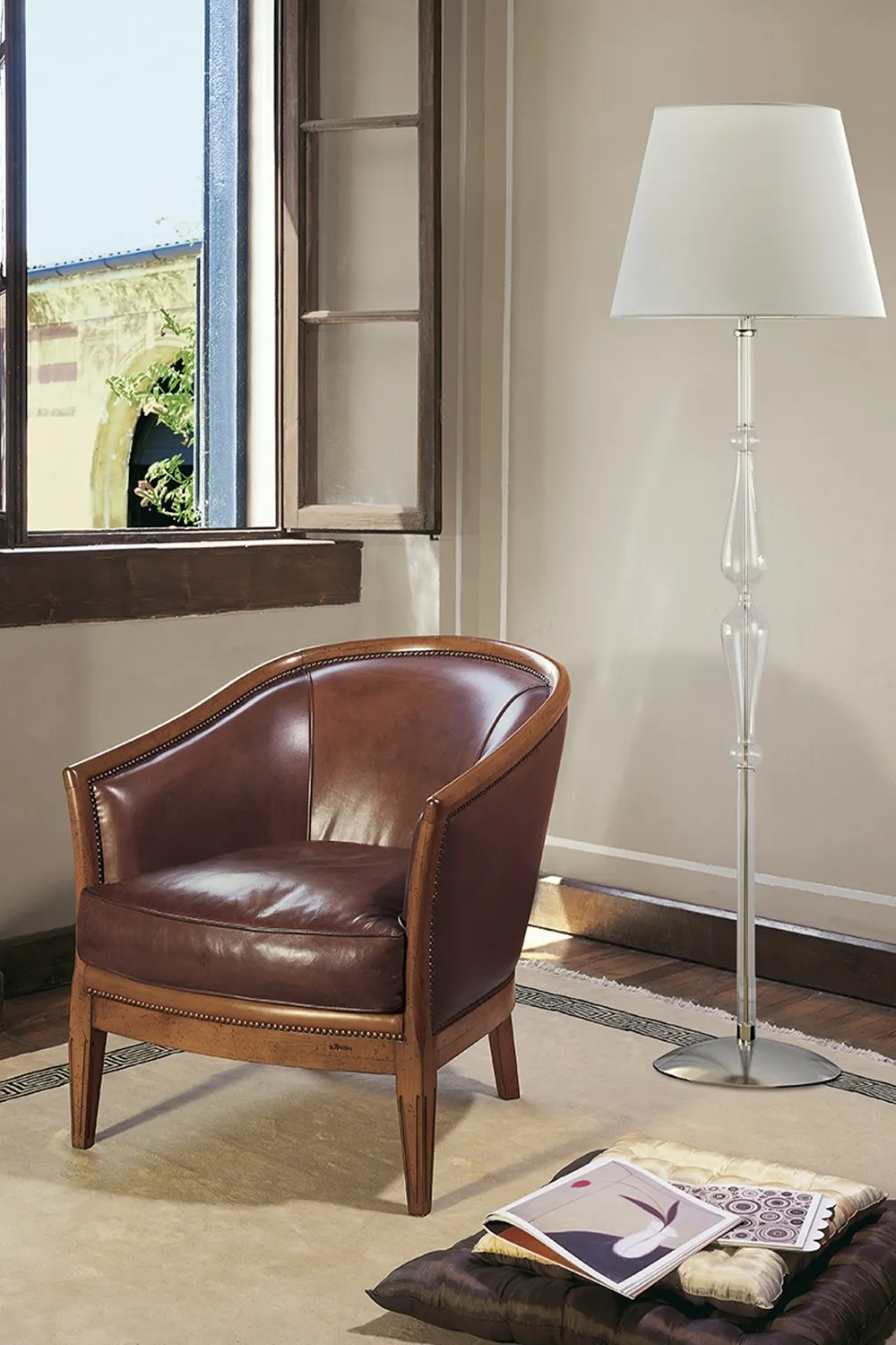 Poltroncina Piazza Le Fablier in pelle accanto a una lampada da terra
