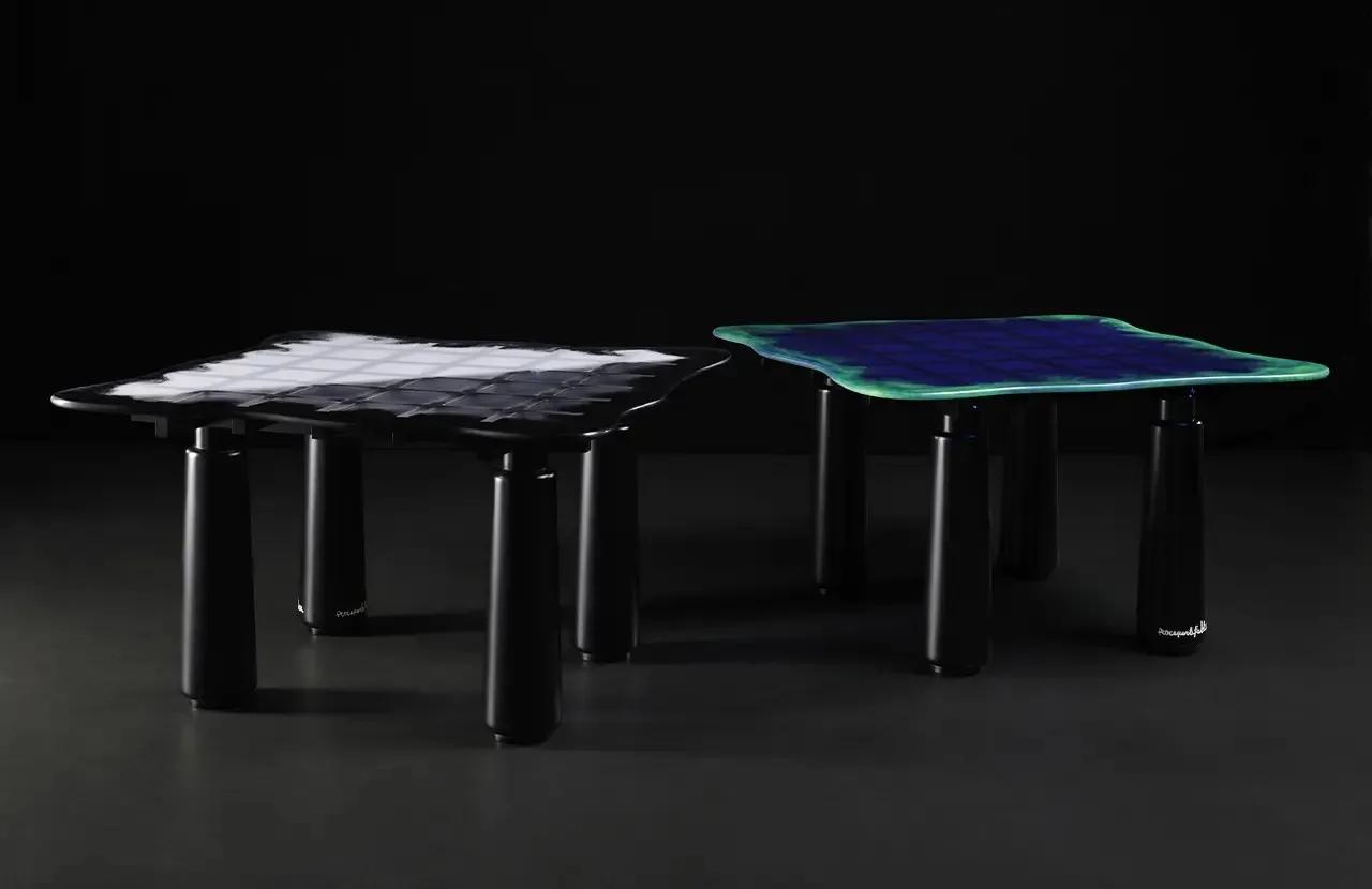 Due tavoli La Distesa Le Fablier con piano in resina colorata e gambe nere su fondo scuro