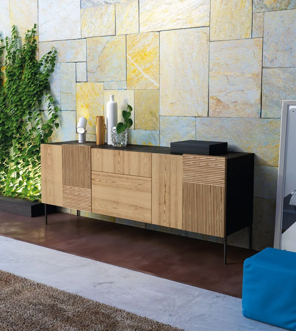 Credenza Nova Stripes Imba in frassino a righe davanti a una parete in pietra