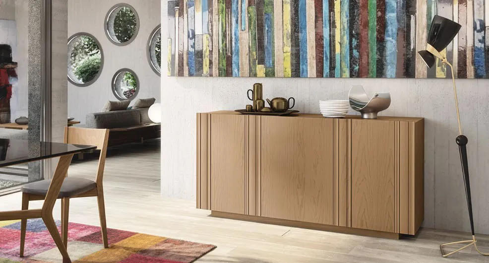 Credenza Nova Vita Imba a tre ante in frassino chiaro sotto una libreria colorata