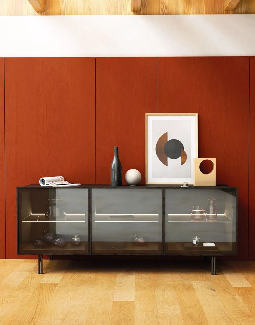 Credenza Nova View Imba a tre ante a vetro su gambe in metallo davanti a una parete rossa