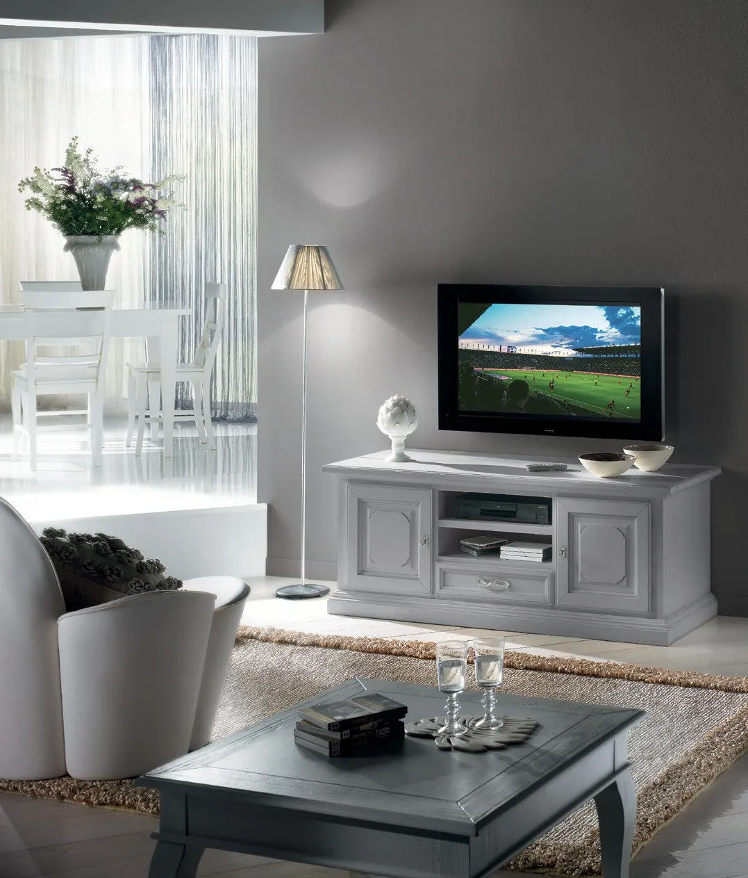 Porta TV Settecento Imba grigio con televisore in un soggiorno con poltrona bianca