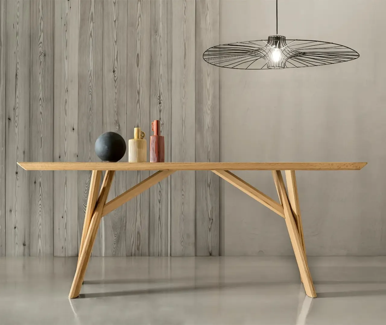 Tavolo Pechino Le Fablier in rovere con gambe incrociate in legno sotto una lampada a sospensione