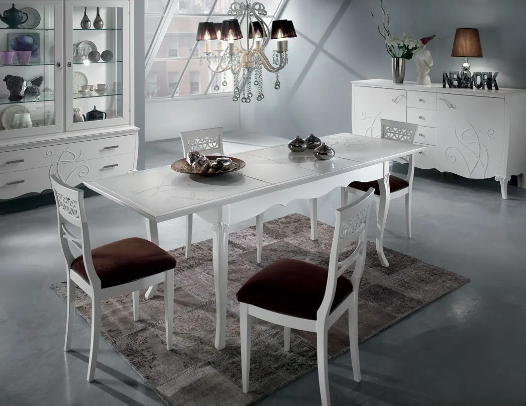 Credenza intagliata Imba Icon 2.0 bianca in una sala da pranzo con lampadario
