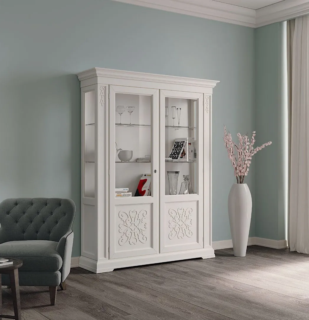 Vetrina decorata Imba Icon 2.0 bianca a due porte davanti a una parete azzurra