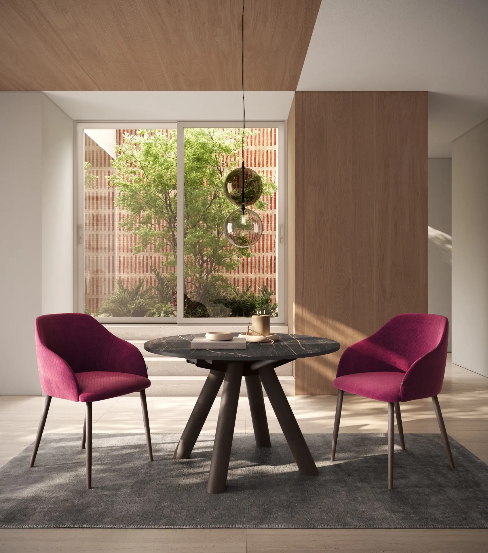Tavolo Note Scavolini rotondo scuro con due poltroncine color magenta davanti alla finestra