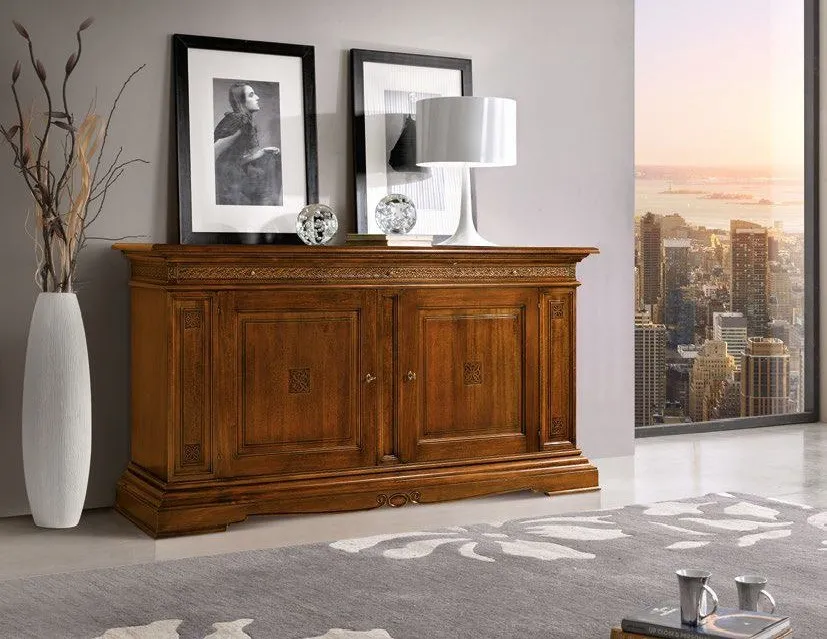 Credenza Trend Style Imba in noce con ante intagliate sotto due quadri, accanto a una vetrata